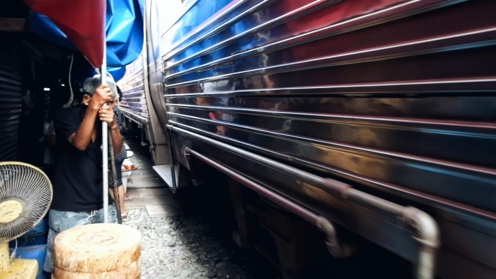 train running through market Maeklong